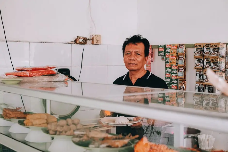 Suasana warung nasi Ibu Sari di Pasar Lama Pulauwunga dengan meja panjang dan kursi plastik